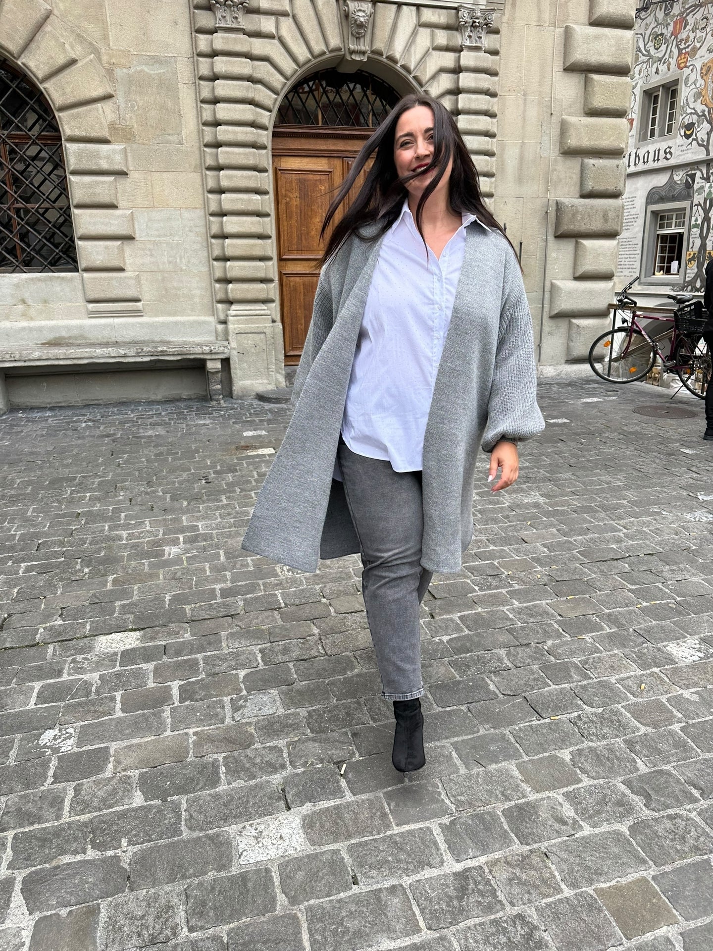 weisse Bluse mit Steinchen und leichter O-Shape  mit hellgrauem Strickmantel und graue Jeans von Mat Fashion - grosse Grössen - DE BOER plus Luzern 